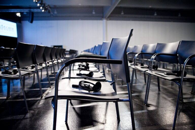 Stuhlreihen mit Audioempfängern für Konferenzteilnehmende – Dolmetsch- und Führungstechnik im Einsatz bei internationalem Event