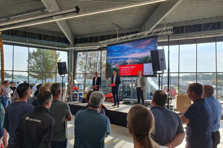 Moderierter Vortrag mit Präsentation auf großem Bildschirm – Konferenztechnik von MEB im Einsatz bei hybrider Veranstaltung