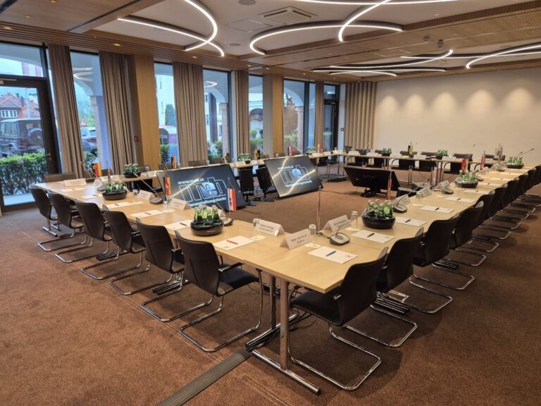 Konferenzraum mit Tischsprechstellen und Bildschirm – professionelle Konferenztechnik von MEB für Hauptversammlungen und Tagungen